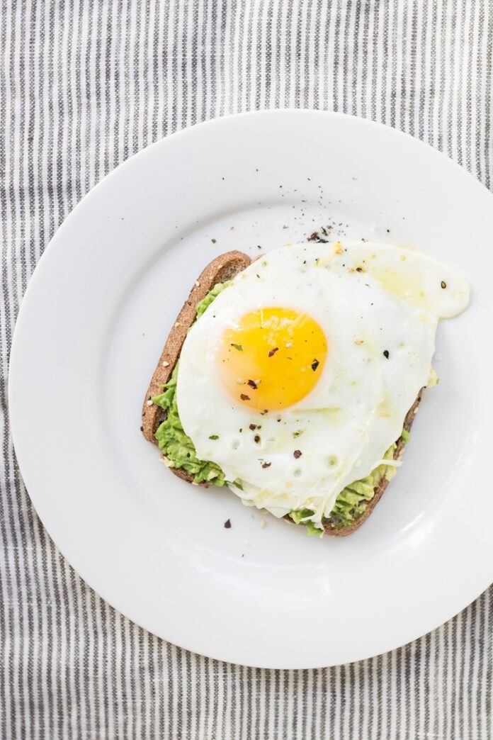 sunny side up egg, lettuce, bread on white ceramic plate